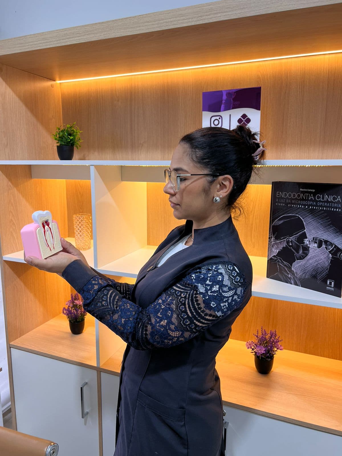 Dra. Marilene Batista explicando tratamento de canal com modelo anatômico de dente